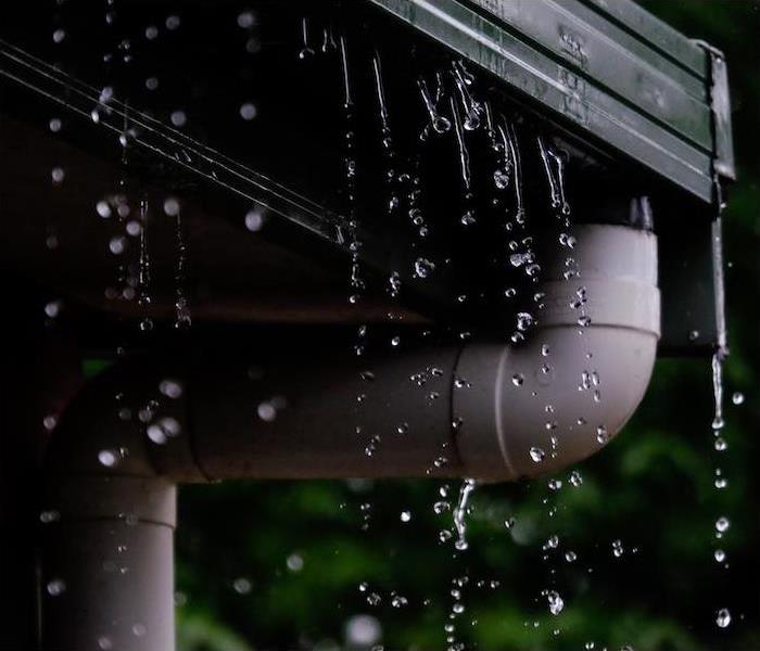 Gutters and pipes outside a house while it's raining.
